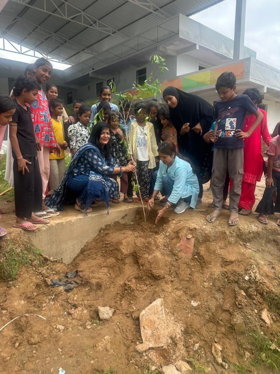 Aangan – children in open-air classroom reading newspapers